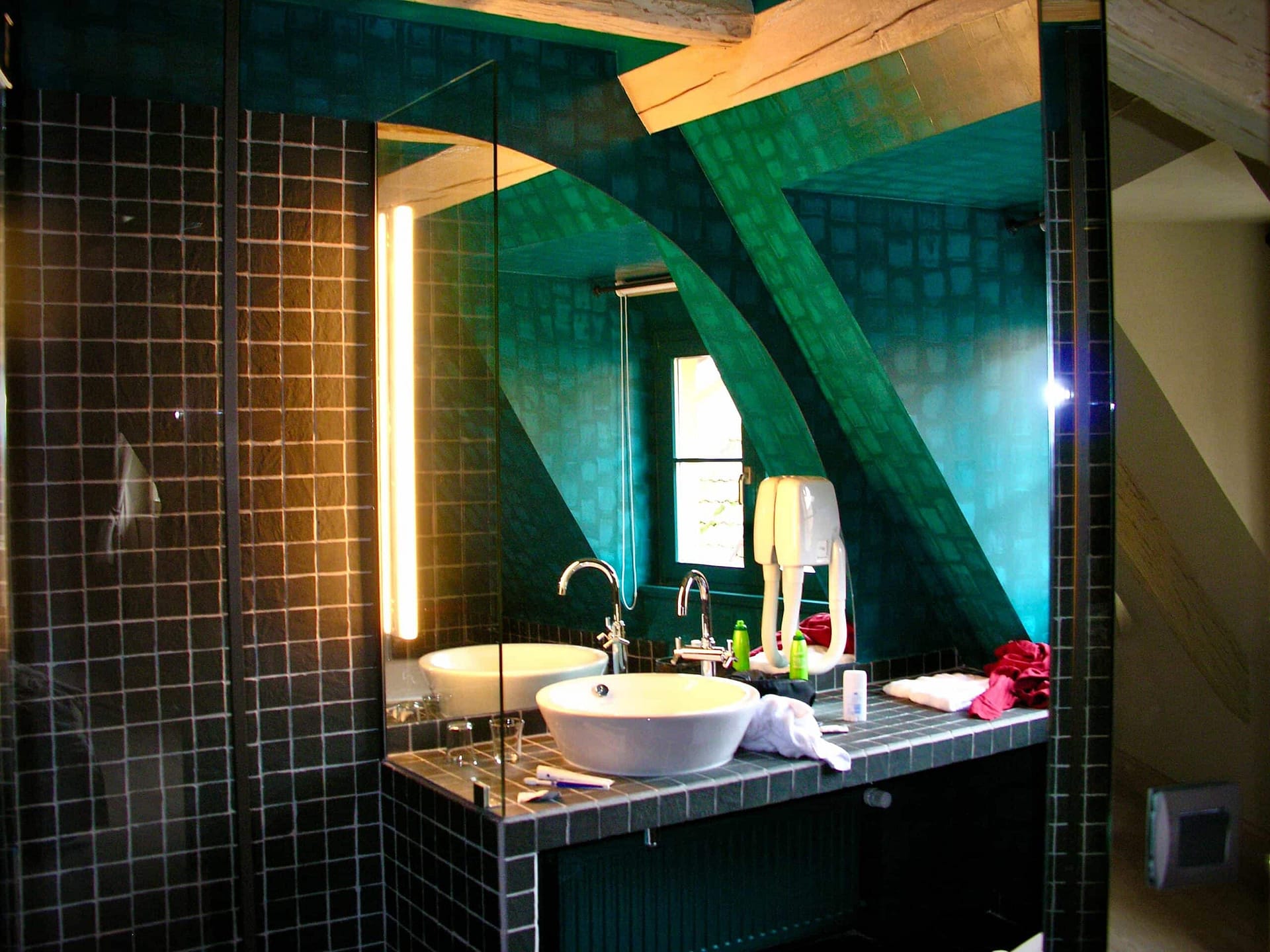 Paroi en verre et vasque d’une salle de bains sous les combles