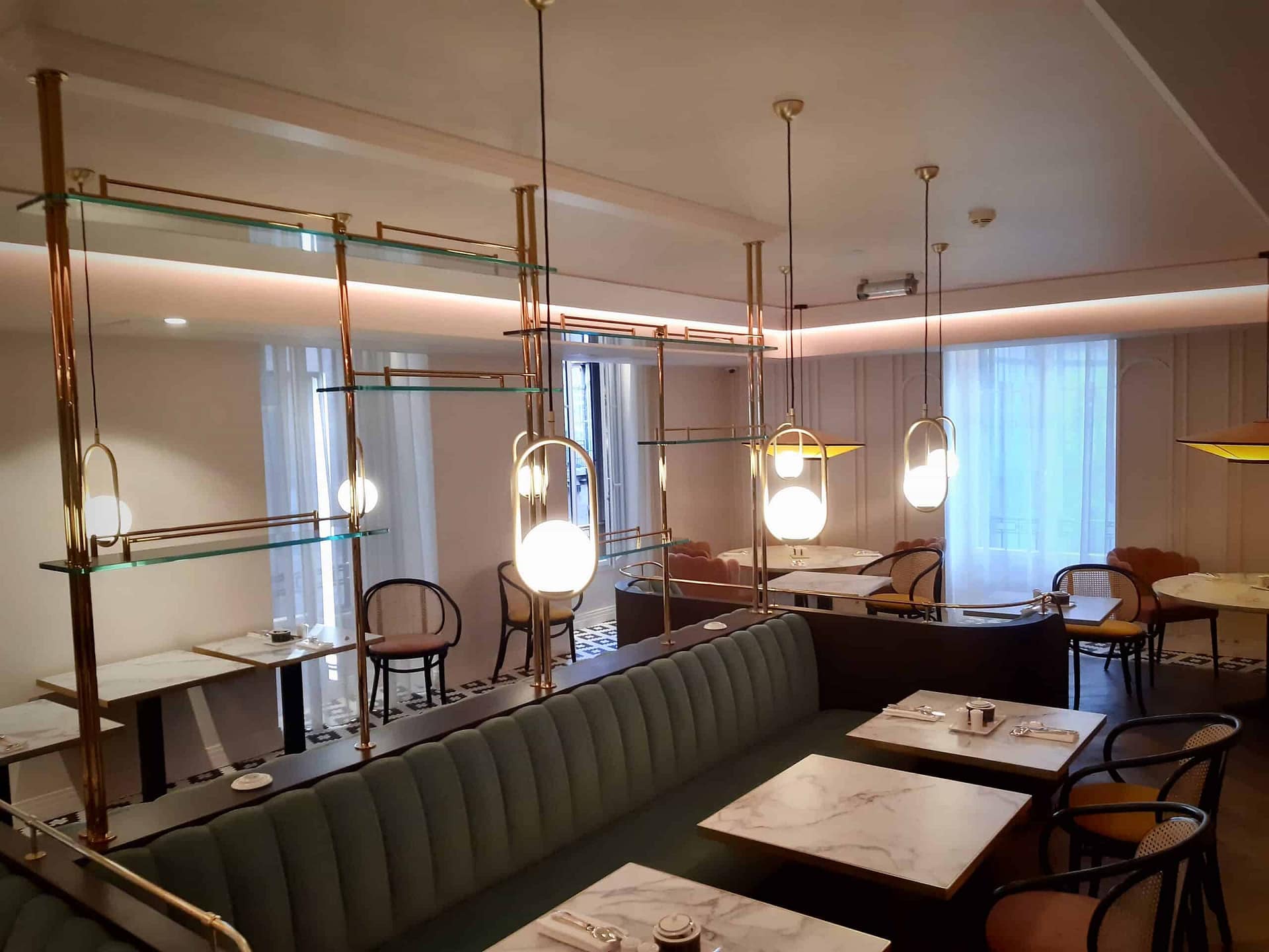 Étagères en verre suspendues au-dessus des banquettes du restaurant