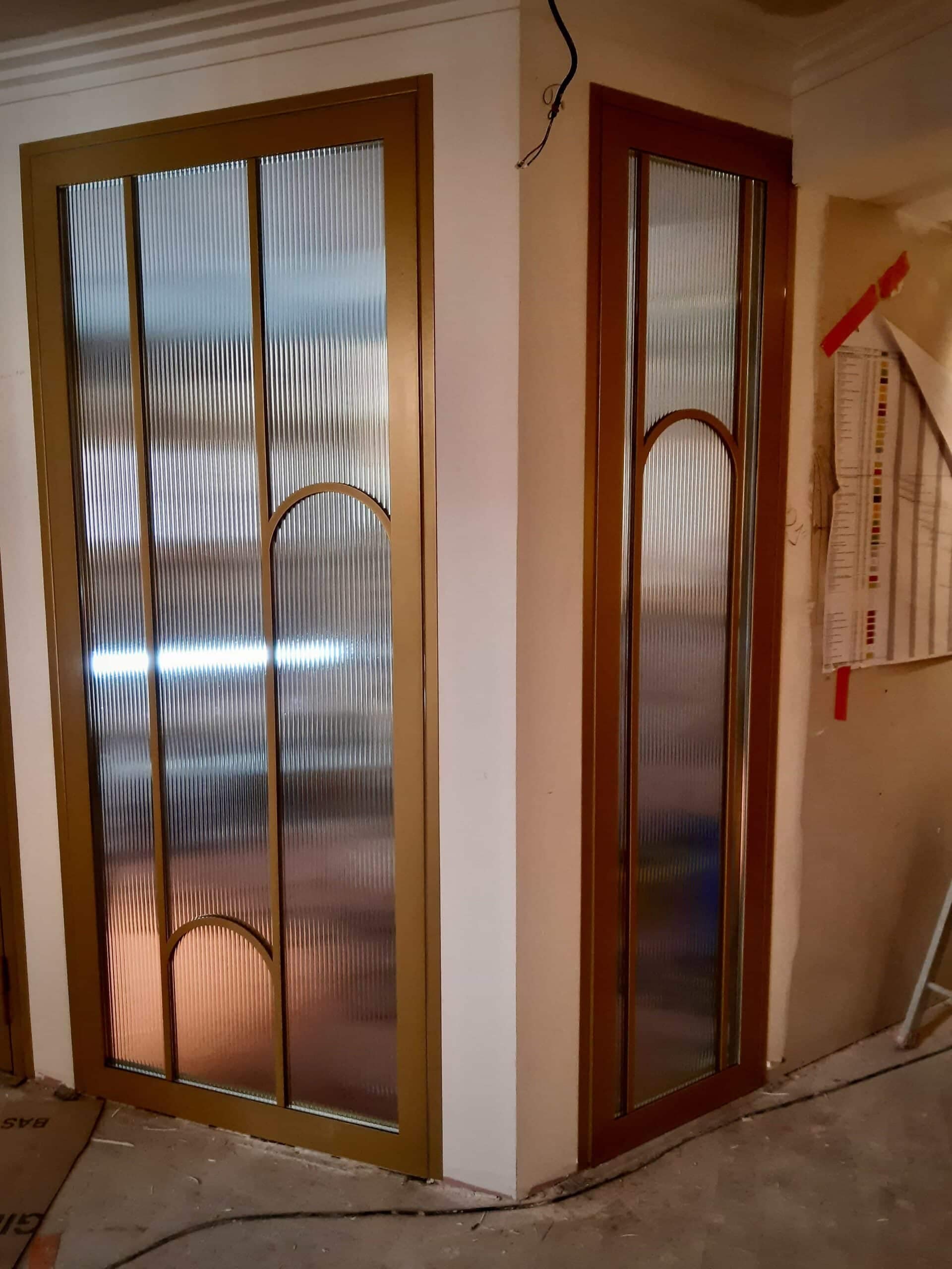 Porte en verre cannelé ornée d’un arc doré