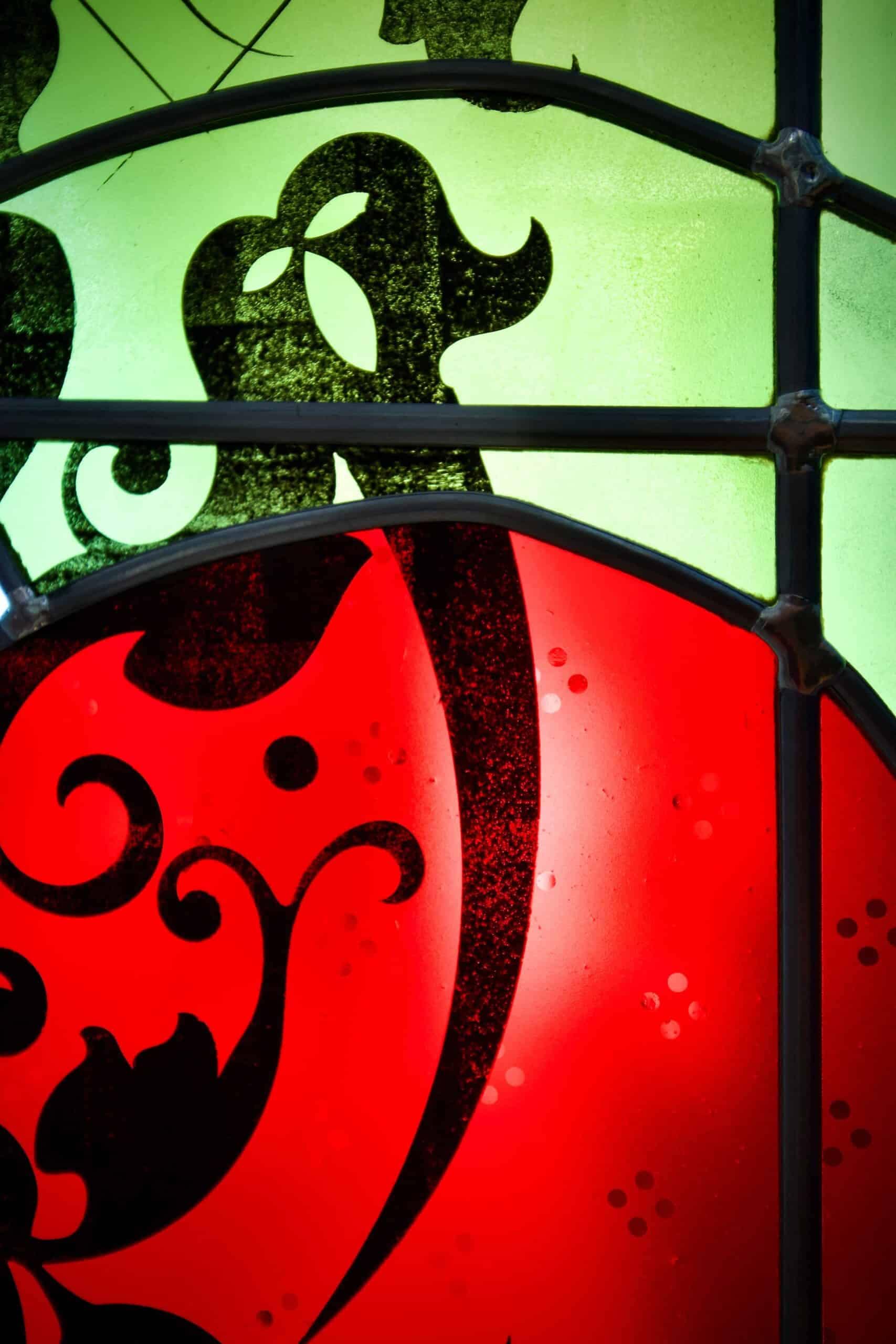 Volutes peintes à la grisaille sur un disque rouge, détail