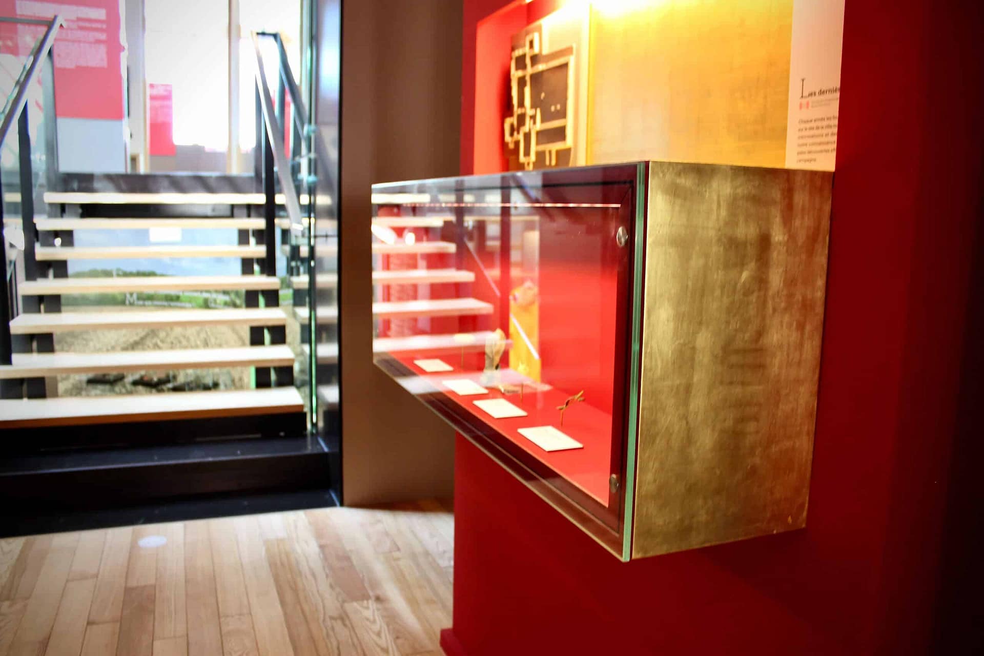 Vitrine en verre sur un meuble rouge près de l’escalier