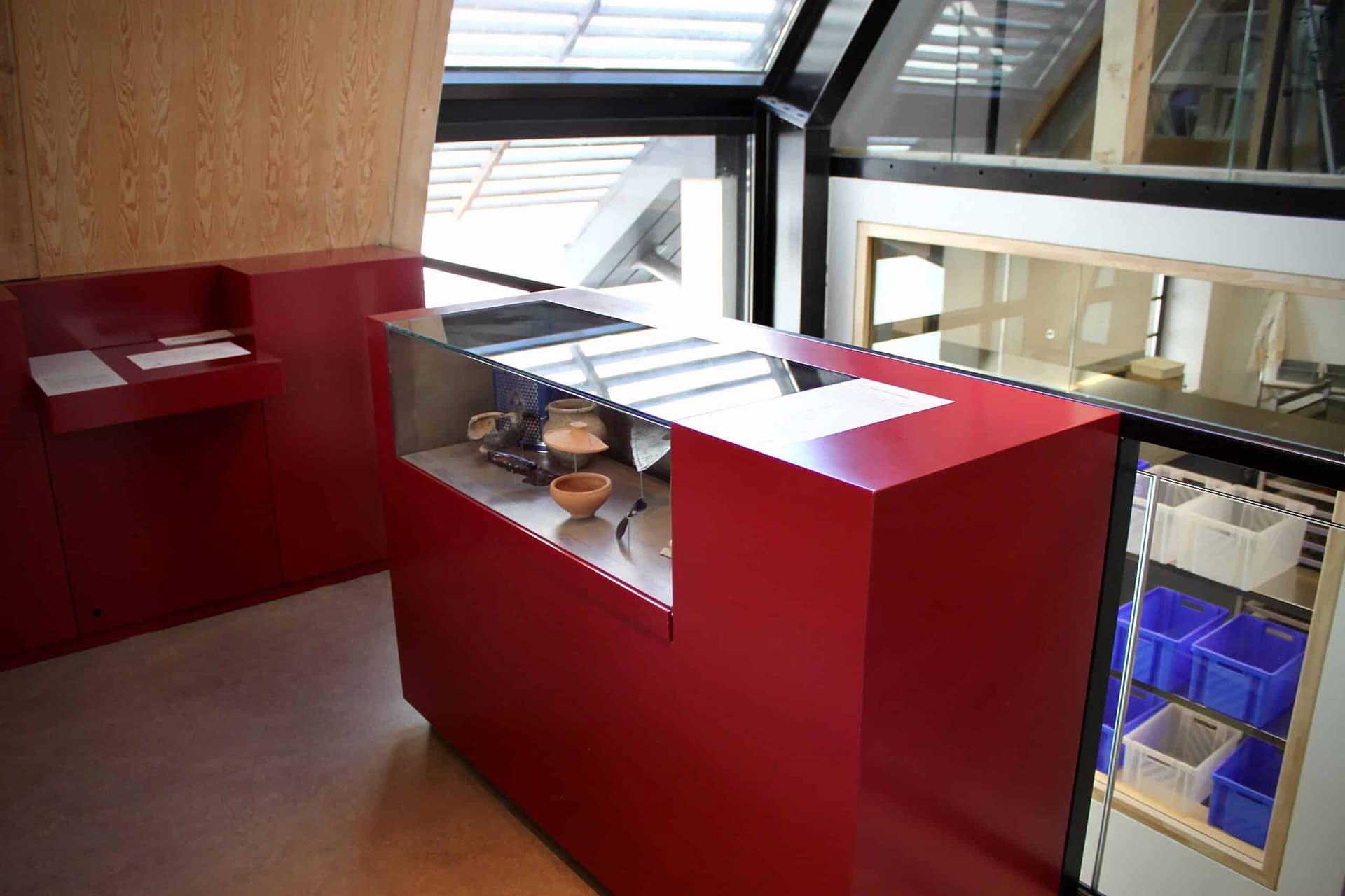 Vitrine en verre posée sur un meuble rouge
