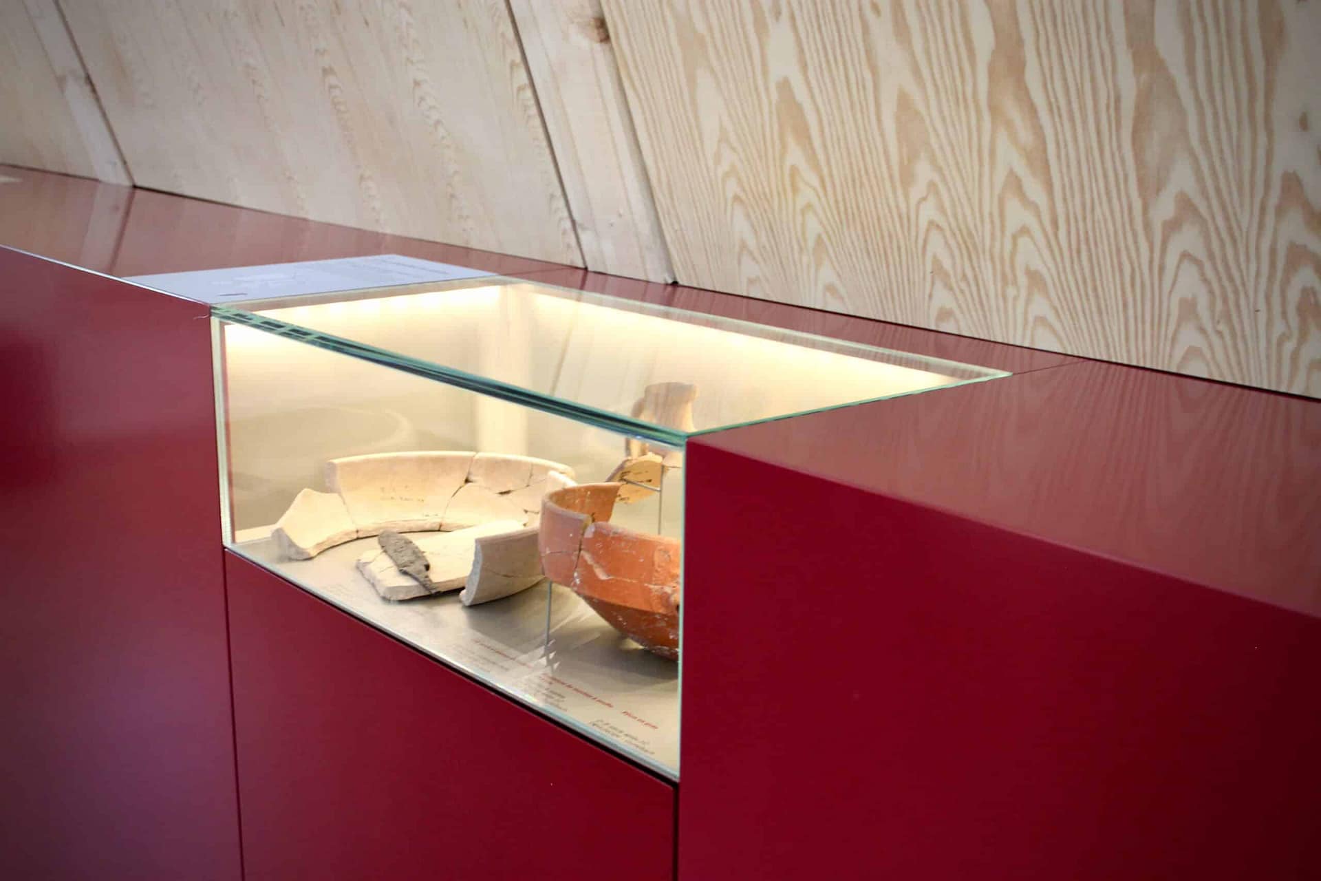 Vitrine en verre éclairée dans un meuble rouge
