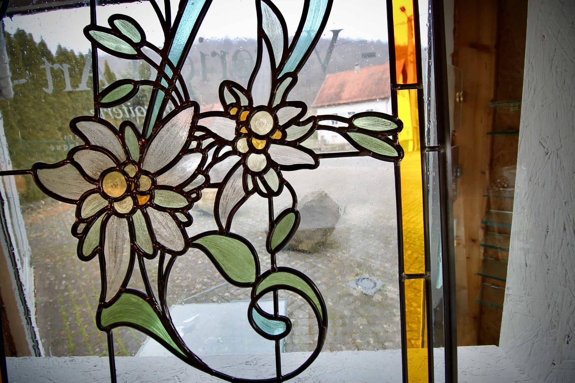 Bouquet d’edelweiss et feuillage vert, détail du vitrail de porte d’entrée