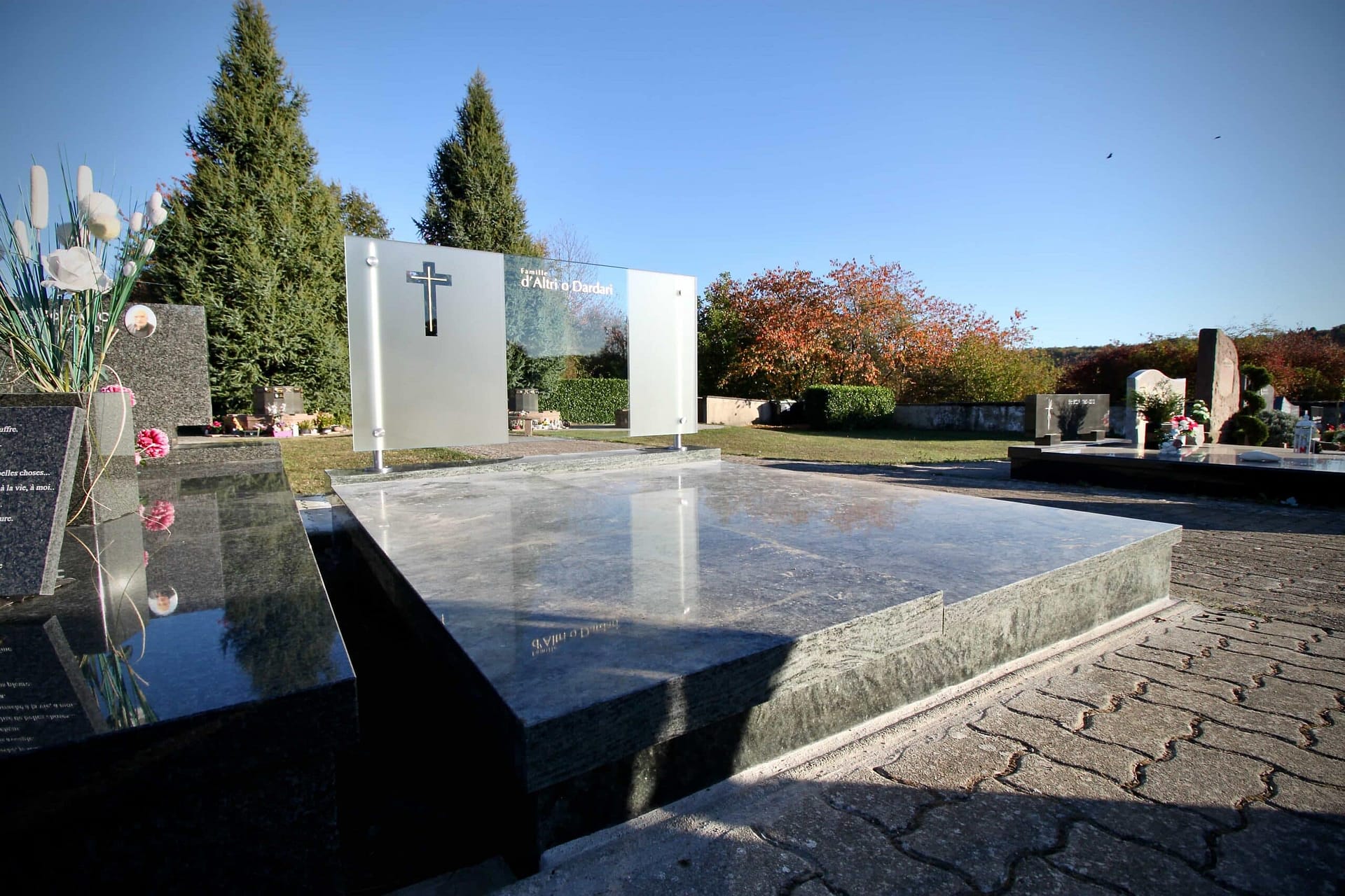 La stèle en verre et la dalle de la tombe, vues de biais