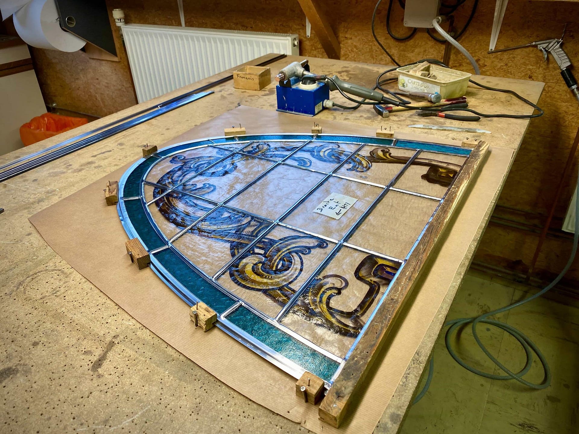 Panneau de vitrail cintré repris sur table à l’atelier