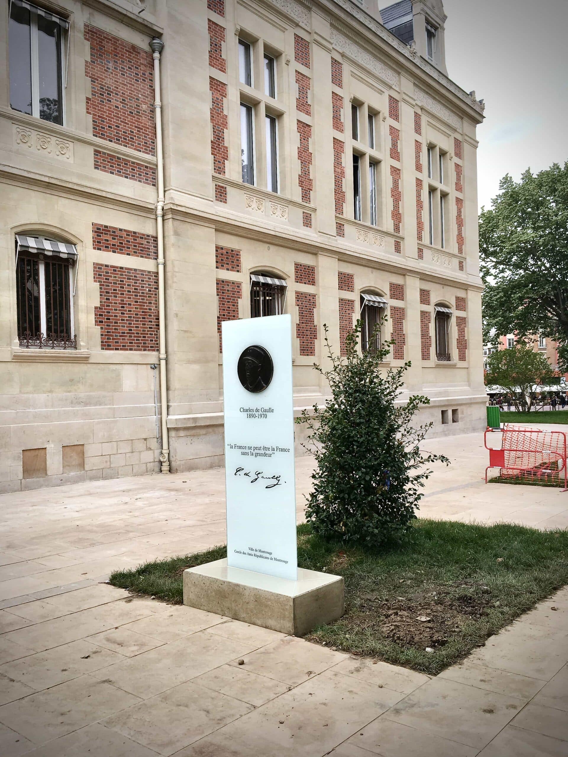 La stèle devant un bâtiment de brique et de pierre